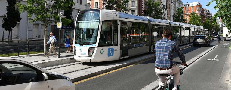 City street featuring a bike lane, car, and transit lane.