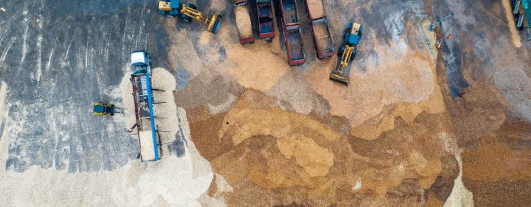 Aerial view of an industrial site with trucks loading sand. 