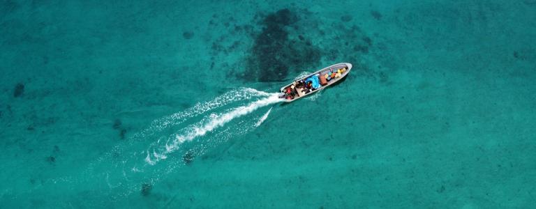 Speed boat in the middle of a bright blue sea.