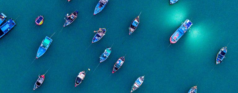 An aerial view of fishing boats anchored at sea at nighttime.