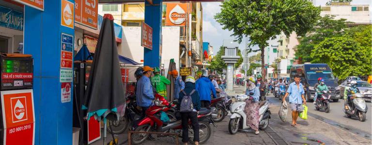 People fill their vehicles at a gas station in Ho Chi Min City