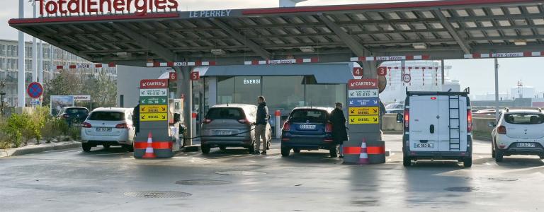 Cars line the pumps at a gas station in France.