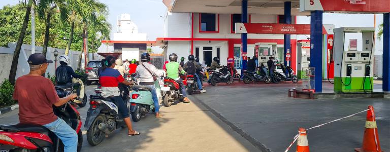 Vehicles wait in line at a gas station.