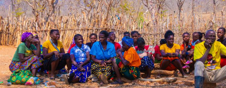 Members of a community in Zambia sit down while participating in a climate vulnerability assessment