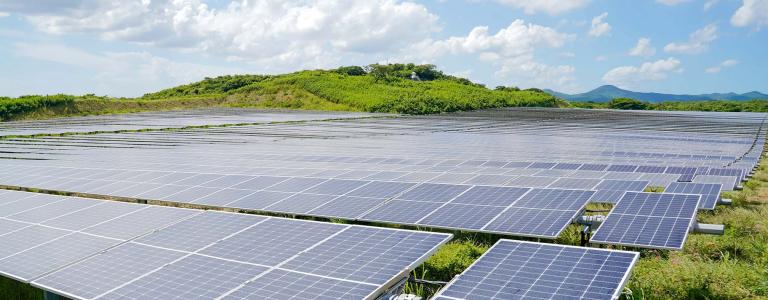 Solar panels with a mountain in the background.