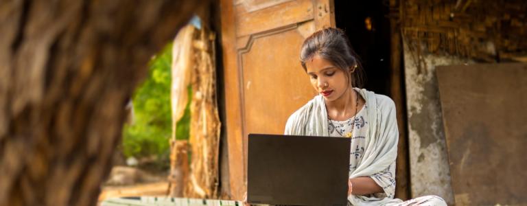 Woman sitting with a computer in her lap.