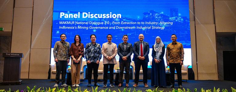 Speakers stand on stage following a panel discussion on critical minerals