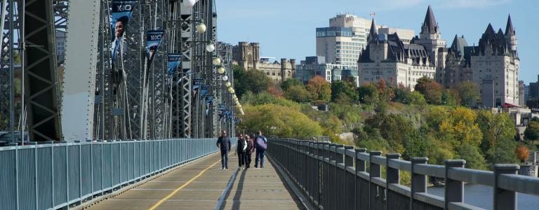 People walk across a the Ottawa-Gatineau bridge
