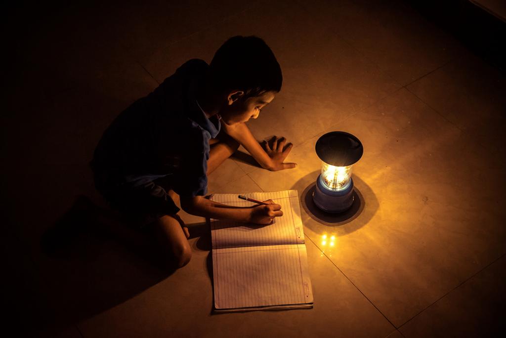 Boy reading by solar lamp