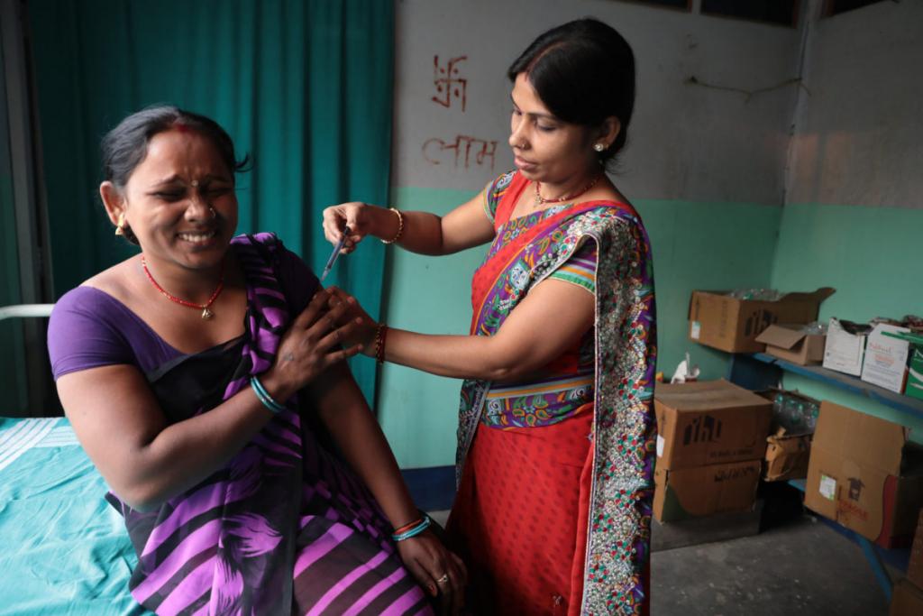 A woman receives a vaccination by a nurse