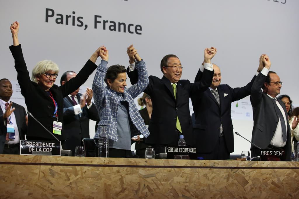 Country delegates raise joined hands to celebrate the signing of the Paris Agreement at the United Nations