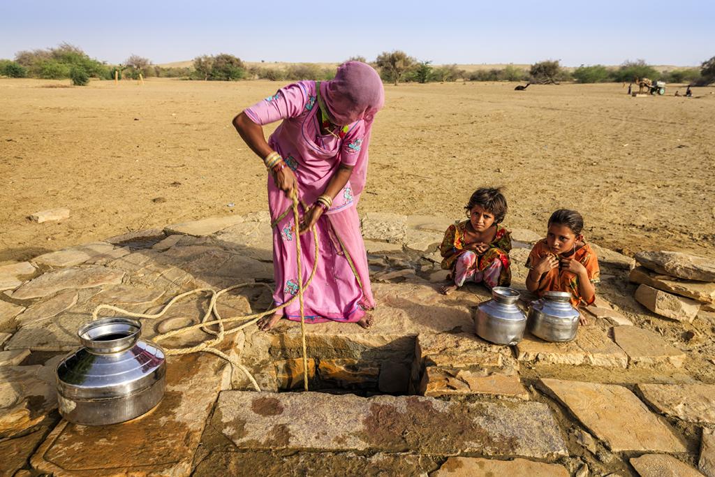 Woman farmer drawing water from well