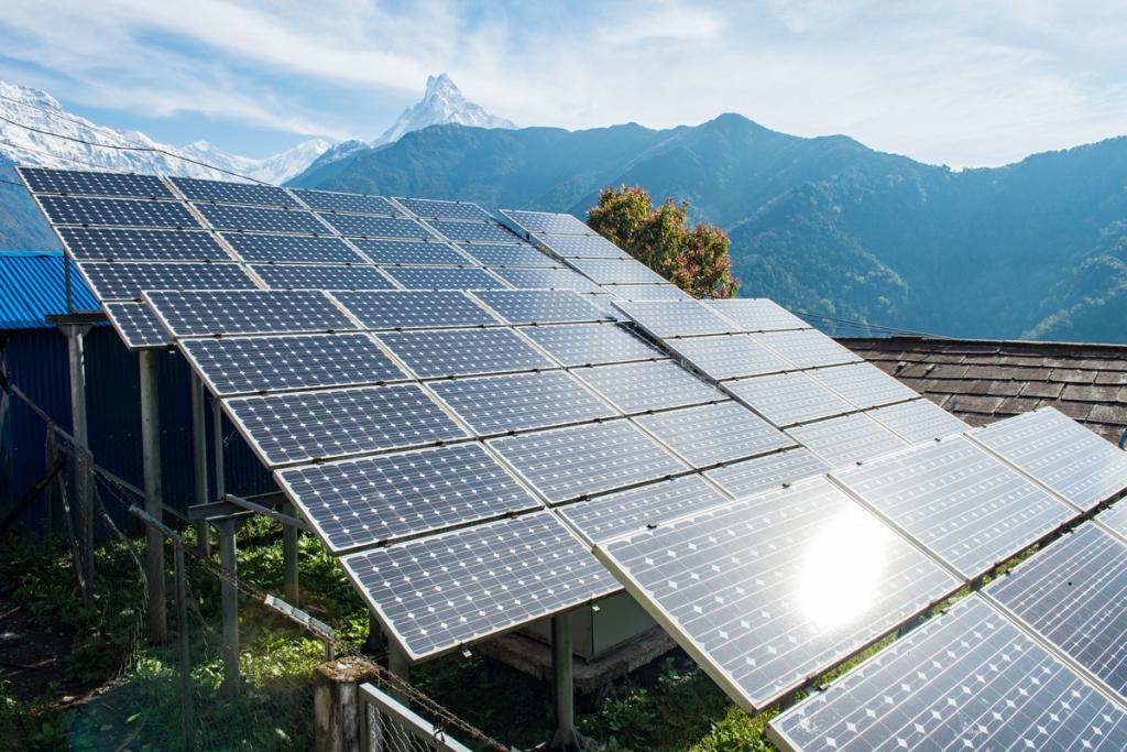 Solar panels in a field with mountains in the background