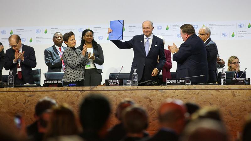 COP21 president Laurent Fabius holds up the text of the Paris Agreement