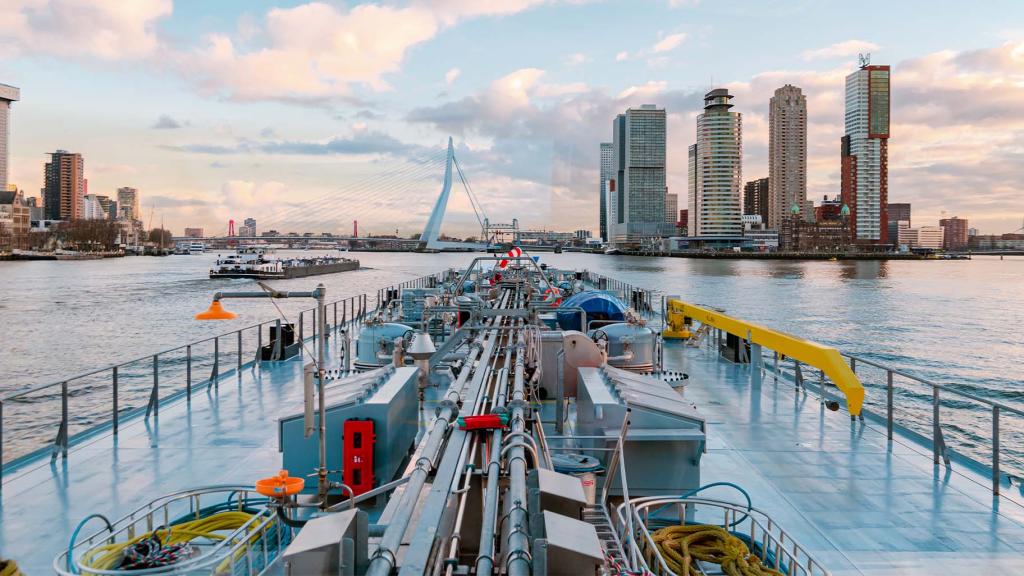 Gas tanks on the river Nieuwe Maas approaching Rotterdam, Netherlands at sunset.
