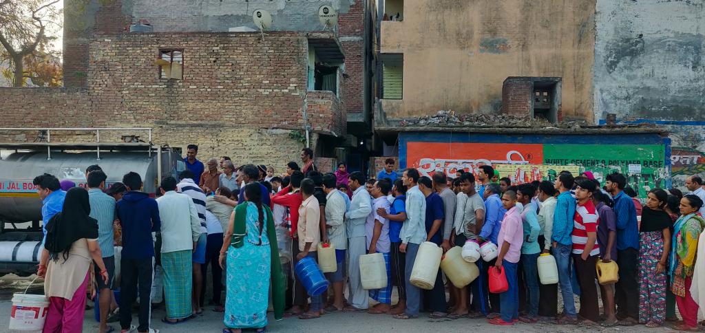 People queue for water in the early morning in New Delhi, India