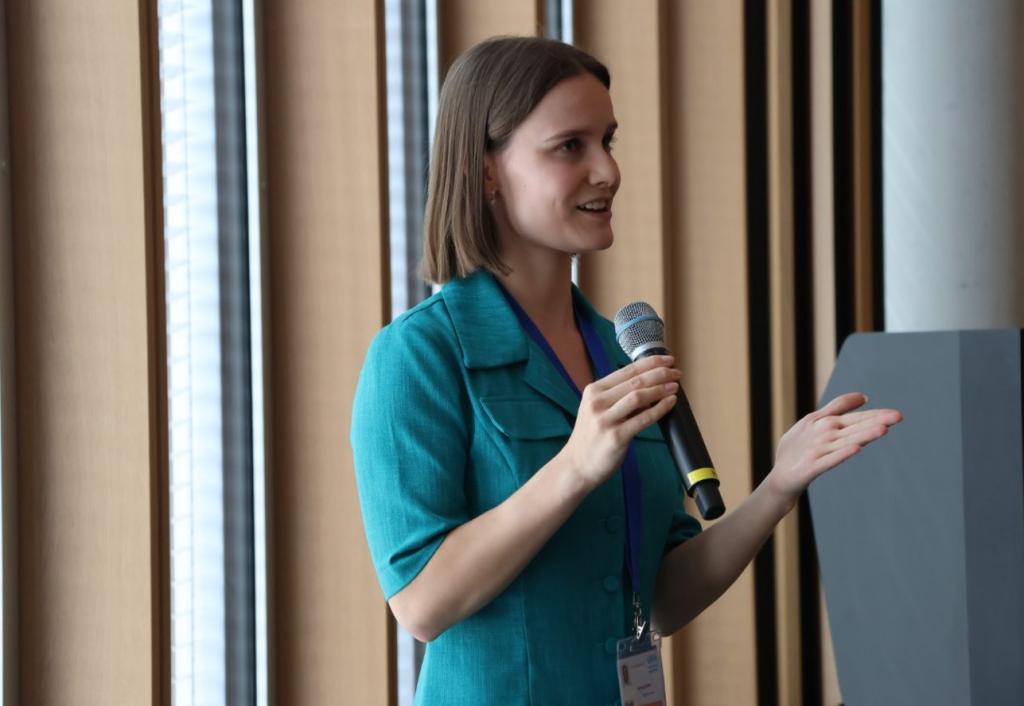 Woman in a turquoise top speaking into a mic 