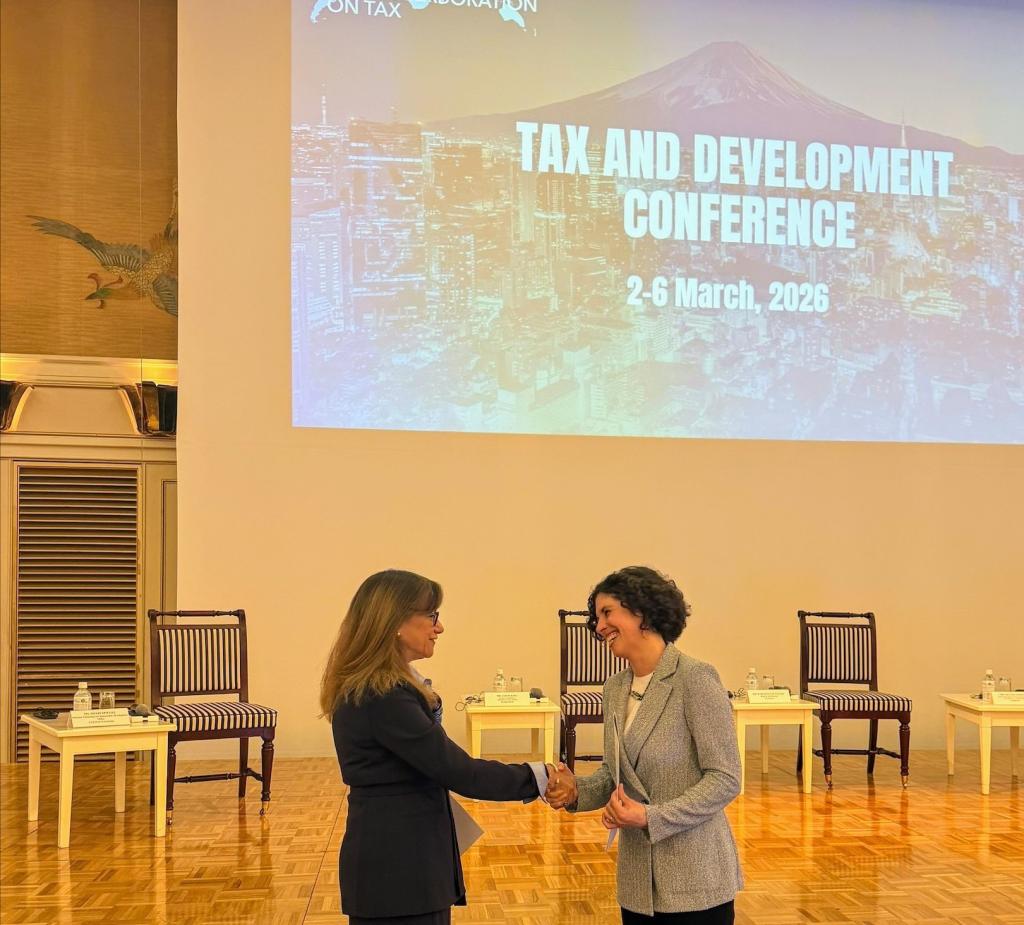 IISD and the OECD representatives shake hands after the signing of the agreement