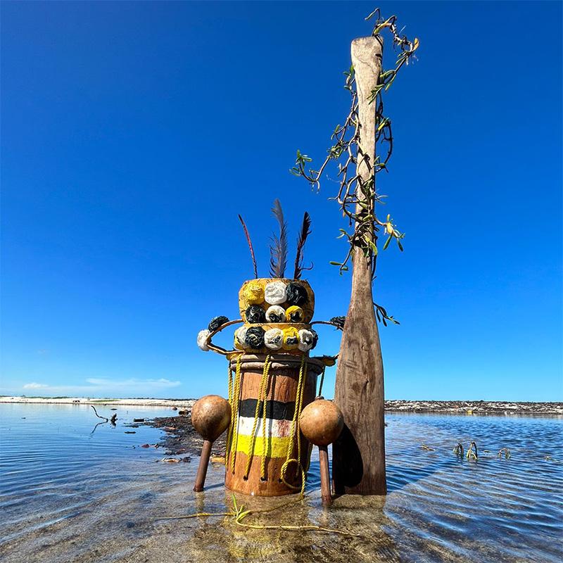 Painted wooden sculpture stands in shallow water