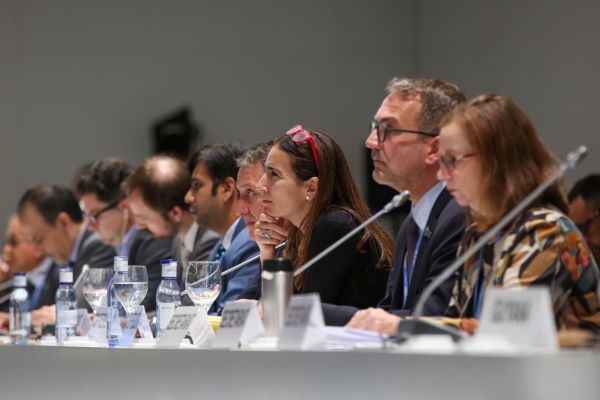 A row of delegates sit on stage in front of their microphones at COP 25 in 2019