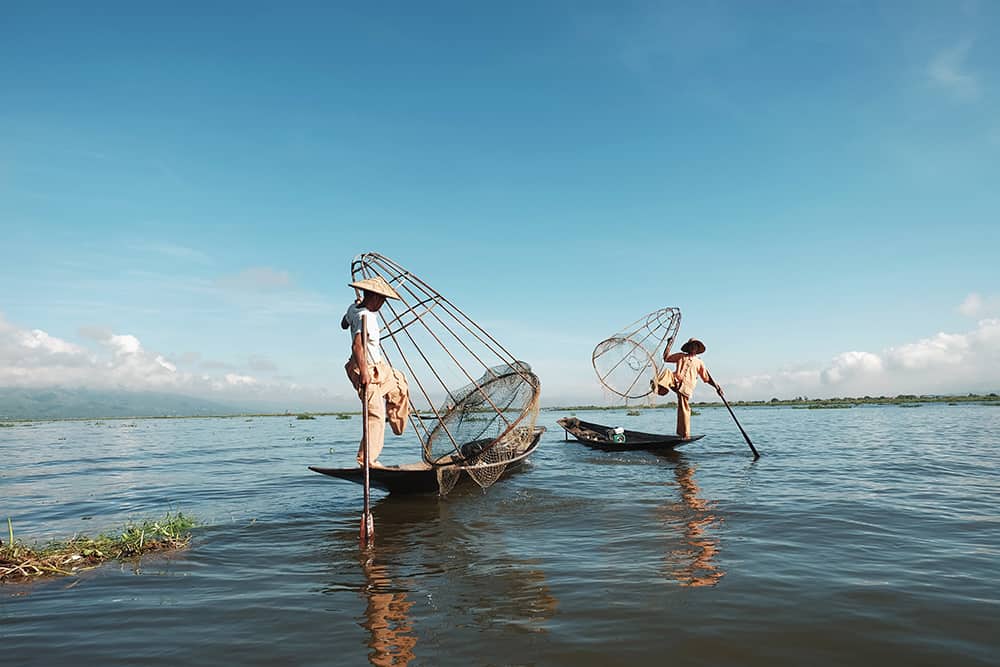 Two men fishing with one leg in Myanmar