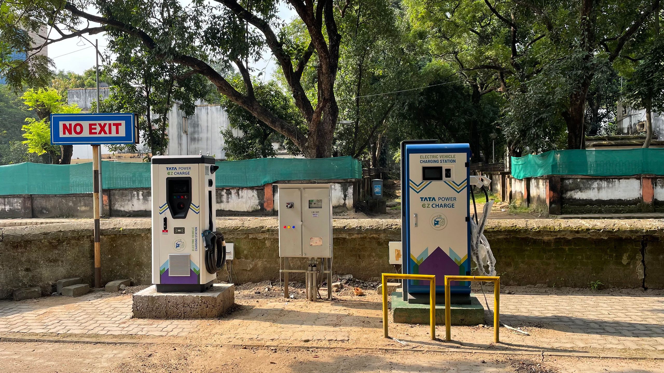 Photo of two electric vehicle charging stations with trees in the background.